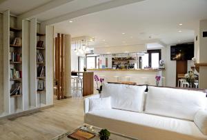 a living room with a white couch and a kitchen at Hotel Rural Oasibeth in Frómista