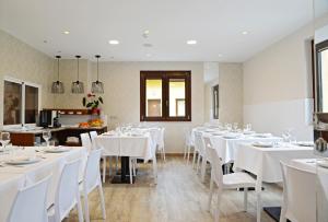 a dining room with white tables and white chairs at Hotel Rural Oasibeth in Frómista
