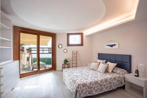 a bedroom with a bed and a large window at OSSUCCIO PRIVATE POOL VILLA ON THE LAKE-by Italian Apartments in Como