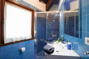 a blue tiled bathroom with a sink and a mirror at OSSUCCIO PRIVATE POOL VILLA ON THE LAKE-by Italian Apartments in Como +60 photos