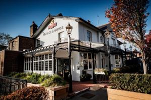 un edificio blanco con una luz de la calle delante de él en The Fox & Goose Hotel, en Londres