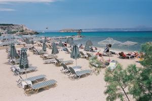 a beach with a lot of chairs and umbrellas at Niriides in Almirida