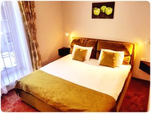 Schlafzimmer mit einem Bett mit weißer Bettwäsche und gelben Kissen in der Unterkunft Vivulskis Apart-Hotel in Vilnius