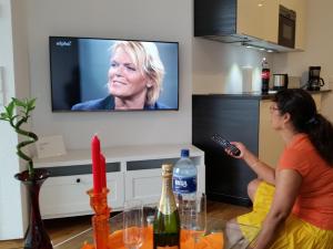 two women in a living room watching a television at Ferienwohnung Koralle - Am Wasser in Bremerhaven