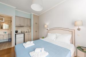 a bedroom with a blue bed with two towels on it at Pansion Ermioni in Skala
