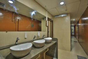 two sinks in a bathroom with two mirrors at Suvidha Ghar AC DORMITORY in Surat +29 photos