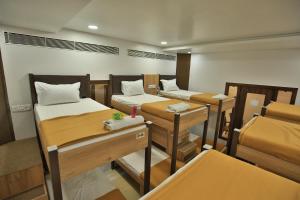 a room with four bunk beds and tables at Suvidha Ghar AC DORMITORY in Surat