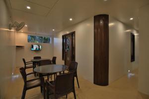 a dining room with tables and chairs and a tv at Suvidha Ghar AC DORMITORY in Surat