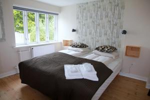 een slaapkamer met een groot bed en handdoeken bij Stevns Klint Strandpension in Rødvig