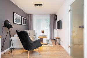 a living room with a black chair and a couch at Apartments Parks of Warsaw by Renters in Warsaw