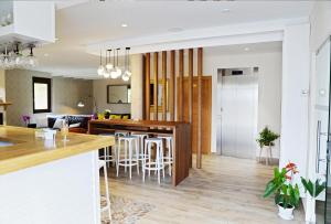 a kitchen and living room with a bar and chairs at Hotel Rural Oasibeth in Frómista