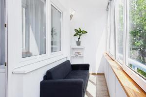 una sala de estar con una silla azul junto a una ventana en Apartments Warsaw Kakowskiego by Renters en Varsovia