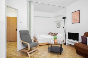 Sala de estar con cama, silla y mesa en Apartments Warsaw Kakowskiego by Renters en Varsovia