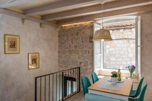 een eetkamer met een tafel en stoelen en een open haard bij OLD TOWN LEA in Dubrovnik