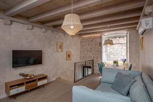 een woonkamer met een blauwe bank en een tv bij OLD TOWN LEA in Dubrovnik
