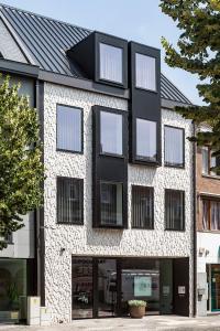 a black and white brick building with windows at Hotel Beila in Bilzen