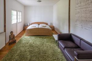 ein Schlafzimmer mit einem Bett und einer Couch in der Unterkunft Ferienhaus im Fachwerkhof 'Haus in Bewegung' in Seelscheid