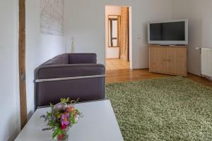 sala de estar con mesa y TV en Ferienhaus im Fachwerkhof 'Haus in Bewegung', en Seelscheid