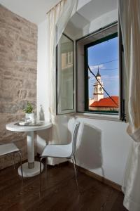 una mesa y una silla en una habitación con ventana en Speruna Luxury Inn, en Split