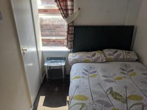 a small bedroom with a bed and a window at MyRoomz New Discovery Hotel in Blackpool