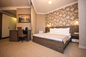 巴统Old Garden Hotel Batumi的一间卧室，配有一张床和一张带椅子的书桌