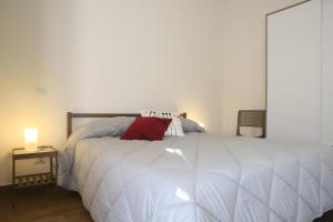 a bedroom with a large white bed with a red pillow at TalialETNA Apartments in Nicolosi