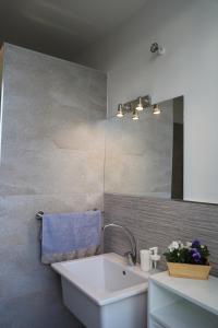 łazienka z umywalką i lustrem w obiekcie TalialETNA Apartments w mieście Nicolosi