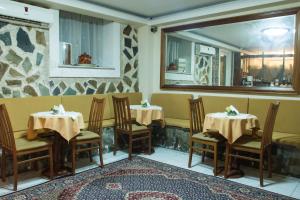 een restaurant met 2 tafels en stoelen en een spiegel bij Porto Lesvos hotel in Mytilini