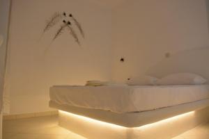 1 dormitorio con 1 cama con luz en la pared en Naxian vacation with sea view, en Naxos Chora