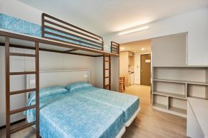 a bedroom with two bunk beds and a kitchen at Alberg Abat Oliba in Montserrat