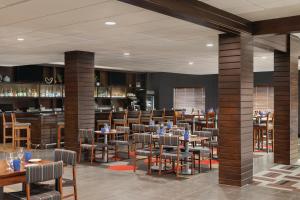 a restaurant with tables and chairs and a bar at Radisson Hotel Oklahoma City Airport in Oklahoma City