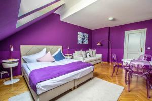 a purple bedroom with a bed and a table at Garden Apartments in Prague