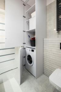 a white laundry room with a washer and dryer at Apartament BLUE Gardenia Dziwnów in Dziwnów