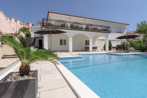 a villa with a swimming pool in front of a house at Villa Gala in Trogir