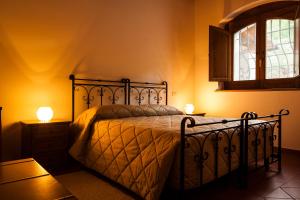 een slaapkamer met een bed, een raam en 2 lampen bij Le Conche country house in Villamaina
