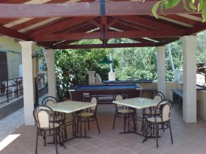 a patio with two tables and a piano at Makis louvlis apartments in Moraitika