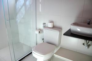 Baño blanco con aseo y lavamanos en Pousada Luzes de Geribá, en Búzios