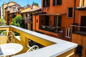 - un balcon avec une table et des chaises dans un bâtiment dans l'établissement La finestra sul canale, à Bologne