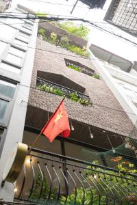 uma bandeira vermelha na lateral de um edifício em Tofu's House - A place called Home em Hanói
