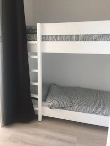 a white bunk bed in a room with a black curtain at Studio pleine vue sur l'océan - Soulac sur Mer in Soulac-sur-Mer