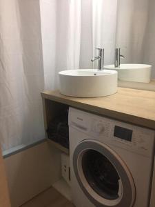 uma casa de banho com um lavatório e uma máquina de lavar roupa em Studio pleine vue sur l'océan - Soulac sur Mer em Soulac-sur-Mer