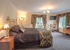 a bedroom with a bed and a desk and windows at Altahammond House in Carrickfergus