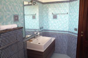 a blue tiled bathroom with a sink and a shower at Villa i Minnulareddi in Giardini Naxos +33 photos