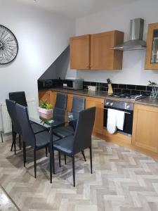 a kitchen with a table and chairs in a kitchen at The Old Post Box in Leeds