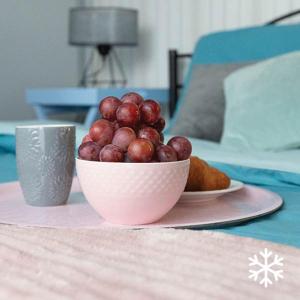 un bol de raisin sur une table avec une tasse dans l'établissement Apartamenty Flat White Zamkowa 4-6, à Zielona Góra