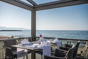a dining room with a table and a view of the ocean at Porto Platanias Beach Luxury Selection - Adults Only in Plataniás