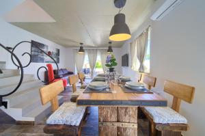 comedor con mesa de madera y sillas en Pax Houses en Krk