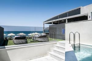 a swimming pool with a view of the ocean at Porto Platanias Beach Luxury Selection - Adults Only in Plataniás