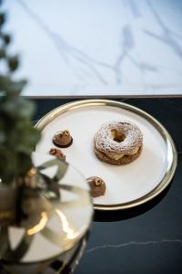 a white plate with a donut on a table at Porto Platanias Beach Luxury Selection - Adults Only in Plataniás