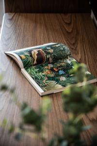 an open book on a table with a plant at Porto Platanias Beach Luxury Selection - Adults Only in Plataniás